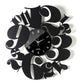 Vista frontale dell'orologio con numeri tipografici particolari e quadrante in vetro Crystal Luxe nero Bodoni di Arti&Mestieri. Base in ferro nero 